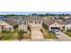 Aerial view of the home within its community, featuring a nearby pond and neighboring houses at 7782 Sail Clover Ln, Zephyrhills, FL 33540