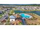 Lovely aerial view of the community pool, clubhouse, lake, and neighborhood at 7782 Sail Clover Ln, Zephyrhills, FL 33540
