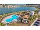 Breathtaking aerial view of the community pool, clubhouse, parking, and lake at 7782 Sail Clover Ln, Zephyrhills, FL 33540