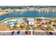 Aerial view of the community clubhouse with pool, lake, playground, and ample parking at 7782 Sail Clover Ln, Zephyrhills, FL 33540
