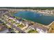 An aerial view of neighborhood houses and a lake, displaying the community setting and waterfront access at 7782 Sail Clover Ln, Zephyrhills, FL 33540
