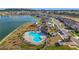 Beautiful aerial view featuring the community pool, playground, clubhouse, lake, and landscape at 7782 Sail Clover Ln, Zephyrhills, FL 33540