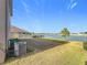 Expansive backyard with lush green grass that stretches out to the serene lake at 7782 Sail Clover Ln, Zephyrhills, FL 33540