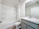 This bathroom features a shower-tub combo and vanity with a gray cabinet at 7782 Sail Clover Ln, Zephyrhills, FL 33540