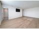 Spacious bedroom with mounted TV and light wood-look floors, offering comfort and style at 7782 Sail Clover Ln, Zephyrhills, FL 33540