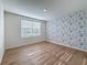 This bedroom has wood-look flooring, natural light from the window and a decorative accent wall at 7782 Sail Clover Ln, Zephyrhills, FL 33540
