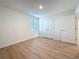 This bedroom has wood-look flooring, natural light from the window and a closet at 7782 Sail Clover Ln, Zephyrhills, FL 33540