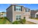 Angle view of the two-story home, showing the side profile, two-car garage, lawn and landscaping at 7782 Sail Clover Ln, Zephyrhills, FL 33540