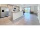A modern kitchen with stainless steel appliances, a center island with granite countertops, and a view of the lake at 7782 Sail Clover Ln, Zephyrhills, FL 33540