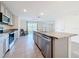 Bright, airy kitchen with stainless steel appliances, granite counters, island, and lake view through sliding glass doors at 7782 Sail Clover Ln, Zephyrhills, FL 33540
