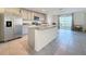Kitchen featuring stainless appliances, granite countertops, a central island, and views of the outdoor lake at 7782 Sail Clover Ln, Zephyrhills, FL 33540