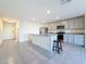Open kitchen featuring stainless appliances, an island with bar stool seating, and ceramic tile floors at 7782 Sail Clover Ln, Zephyrhills, FL 33540