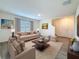Bright living room featuring a plush area rug, neutral-toned furniture and plenty of natural light at 7782 Sail Clover Ln, Zephyrhills, FL 33540