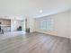 Open-plan living room with hardwood floors, a window, and a sliding door to the outside at 7782 Sail Clover Ln, Zephyrhills, FL 33540