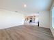 Open-concept living area with new hardwood floors, leading to a kitchen with stainless steel appliances at 7782 Sail Clover Ln, Zephyrhills, FL 33540