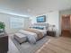 Staged primary bedroom featuring modern decor, wood-look floors, and ample natural light at 7782 Sail Clover Ln, Zephyrhills, FL 33540