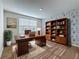 This home office features a decorative accent wall, a bookshelf, and a large desk at 7782 Sail Clover Ln, Zephyrhills, FL 33540