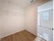 Open walk-in closet with shelving and wood-look floors, leading to adjoining room with natural light at 7782 Sail Clover Ln, Zephyrhills, FL 33540