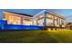 Backyard with large covered patio, landscaping, and a glowing blue-tiled water feature at 813 Manns Harbor Dr, Apollo Beach, FL 33572