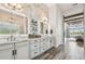 Bathroom with dual vanities, marble countertops, decorative backsplash, and wood-look tile flooring at 813 Manns Harbor Dr, Apollo Beach, FL 33572