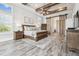 Spacious main bedroom with a wood-beamed ceiling, ceiling fan, and sliding barn door to ensuite at 813 Manns Harbor Dr, Apollo Beach, FL 33572