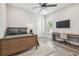 Modern bedroom with ceiling fan, mounted TV, a desk and neutral tones at 813 Manns Harbor Dr, Apollo Beach, FL 33572
