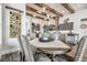Dining room featuring wood floors and a wine rack near a kitchen with gray cabinets and exposed beams at 813 Manns Harbor Dr, Apollo Beach, FL 33572