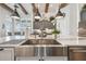 Close-up of kitchen sink featuring stainless steel appliances, white cabinets and white marbled countertops at 813 Manns Harbor Dr, Apollo Beach, FL 33572