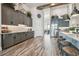 Modern kitchen featuring gray cabinetry, wood flooring, stainless steel appliances, and a quartz countertop island at 813 Manns Harbor Dr, Apollo Beach, FL 33572