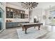 Open concept living area featuring a pool table, custom bar, and unique ceiling fan at 813 Manns Harbor Dr, Apollo Beach, FL 33572