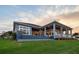A stunning rear view of the home showcasing an infinity pool overlooking a beautiful twilight waterfront at 813 Manns Harbor Dr, Apollo Beach, FL 33572