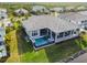 A stunning aerial rear view of the home showcasing an infinity pool and lounge chairs overlooking a waterfront at 813 Manns Harbor Dr, Apollo Beach, FL 33572
