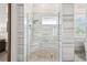 Modern glass shower with marble-look tile and pebble flooring at 813 Manns Harbor Dr, Apollo Beach, FL 33572