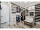 Spacious walk-in closet with custom shelves, drawers, a bench, and chandelier at 813 Manns Harbor Dr, Apollo Beach, FL 33572