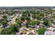 Aerial view of a home with a pool, lush green trees, and a serene neighborhood setting at 8401 Stillbrook Ave, Tampa, FL 33615