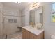 Modern bathroom featuring a walk-in shower, a stylish vanity with marble countertop and gold fixtures at 8401 Stillbrook Ave, Tampa, FL 33615