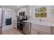 Modern kitchen featuring stainless steel appliances, quartz countertops, and a farmhouse sink at 8401 Stillbrook Ave, Tampa, FL 33615