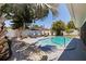 Backyard with a sparkling pool, lounge furniture, and mature trees at 8401 Stillbrook Ave, Tampa, FL 33615