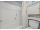 This bathroom features white tiling, shower with grab bar, and cabinet offering extra storage at 9112 Suffield Ct, Tampa, FL 33615