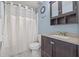 This bathroom has a granite countertop, wood cabinet and shower with a white shower curtain at 9112 Suffield Ct, Tampa, FL 33615
