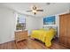 Bright bedroom with laminate flooring, ceiling fan, and a large window allowing ample sunlight at 9112 Suffield Ct, Tampa, FL 33615