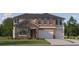 A stone and stucco two-story home with a two-car garage, and a well manicured lawn at 9616 Runaway Breeze Dr, Land O Lakes, FL 34637