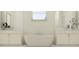 Spa-like bathroom with a freestanding tub, dual vanities, and plenty of natural light at 9652 Runaway Breeze Dr, Land O Lakes, FL 34637