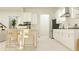 Modern white kitchen with island, stainless steel appliances, and breakfast bar seating, perfect for casual dining at 9652 Runaway Breeze Dr, Land O Lakes, FL 34637