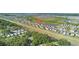 An aerial view shows modern homes with a lake and green space in a planned community setting at 9893 Branching Ship Trce, Wesley Chapel, FL 33545
