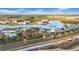 Beautiful aerial view of a community featuring a large turquoise lagoon, palm trees and community amenities at 9893 Branching Ship Trce, Wesley Chapel, FL 33545