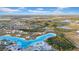 Expansive aerial view of a community with a large turquoise lagoon and surrounding residential area at 9893 Branching Ship Trce, Wesley Chapel, FL 33545