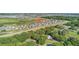 Overhead shot of a housing development featuring modern homes, scenic lakes, and lush greenery at 9893 Branching Ship Trce, Wesley Chapel, FL 33545