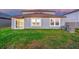 Green backyard with well maintained lawn, slider to patio, and AC condensers at 9893 Branching Ship Trce, Wesley Chapel, FL 33545
