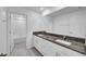 Bright bathroom with granite countertop and a double sink vanity next to a bath with white tile at 9893 Branching Ship Trce, Wesley Chapel, FL 33545